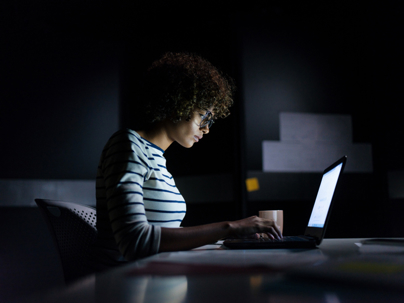woman working overtime in a dark room
